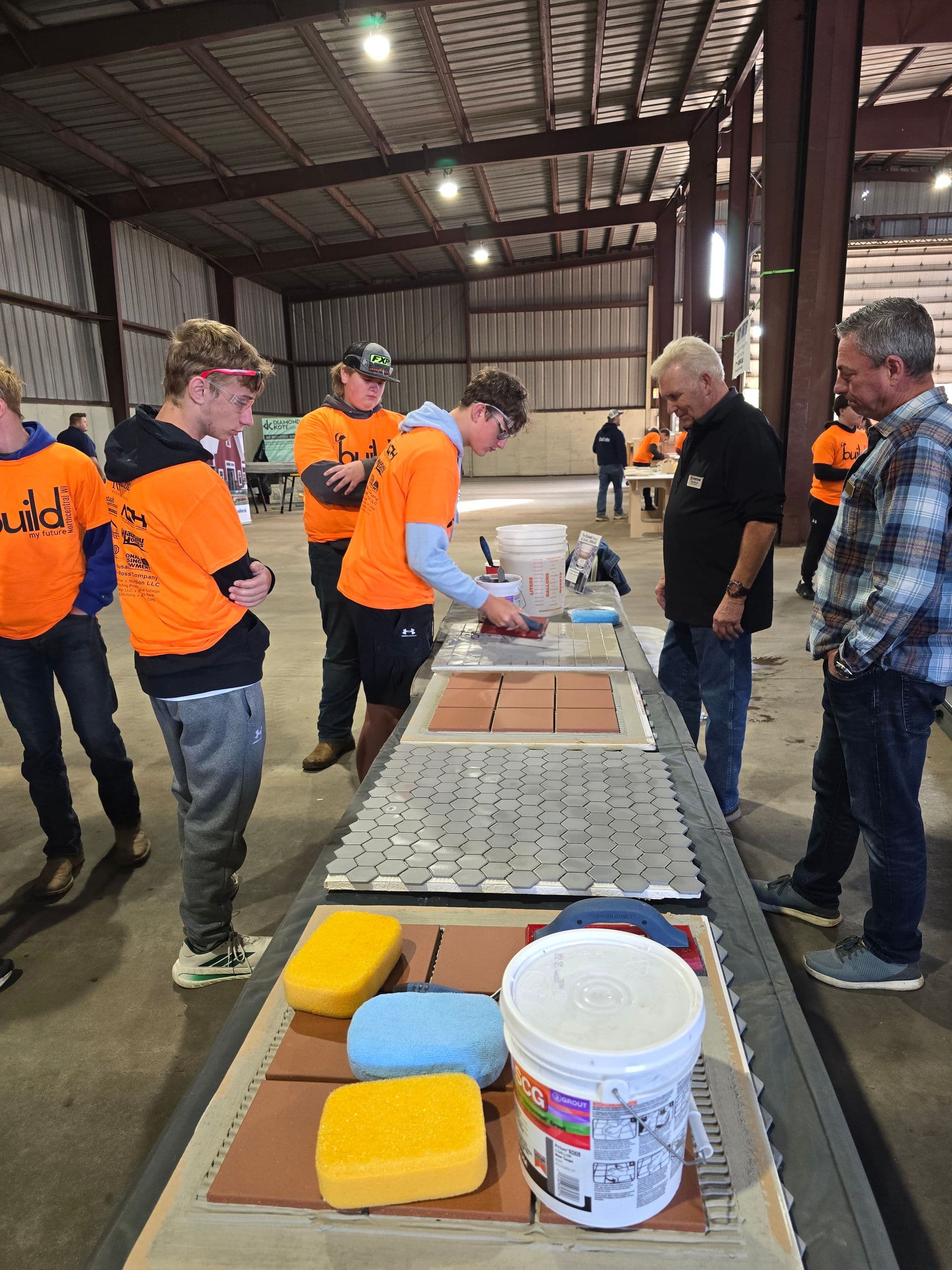Students work with professional tile-setting materials and tools at the Floorology and Custom Building Products demonstration station. Approximately 1,300 students from area schools attended the fifth annual event. Photo courtesy of Floorology.